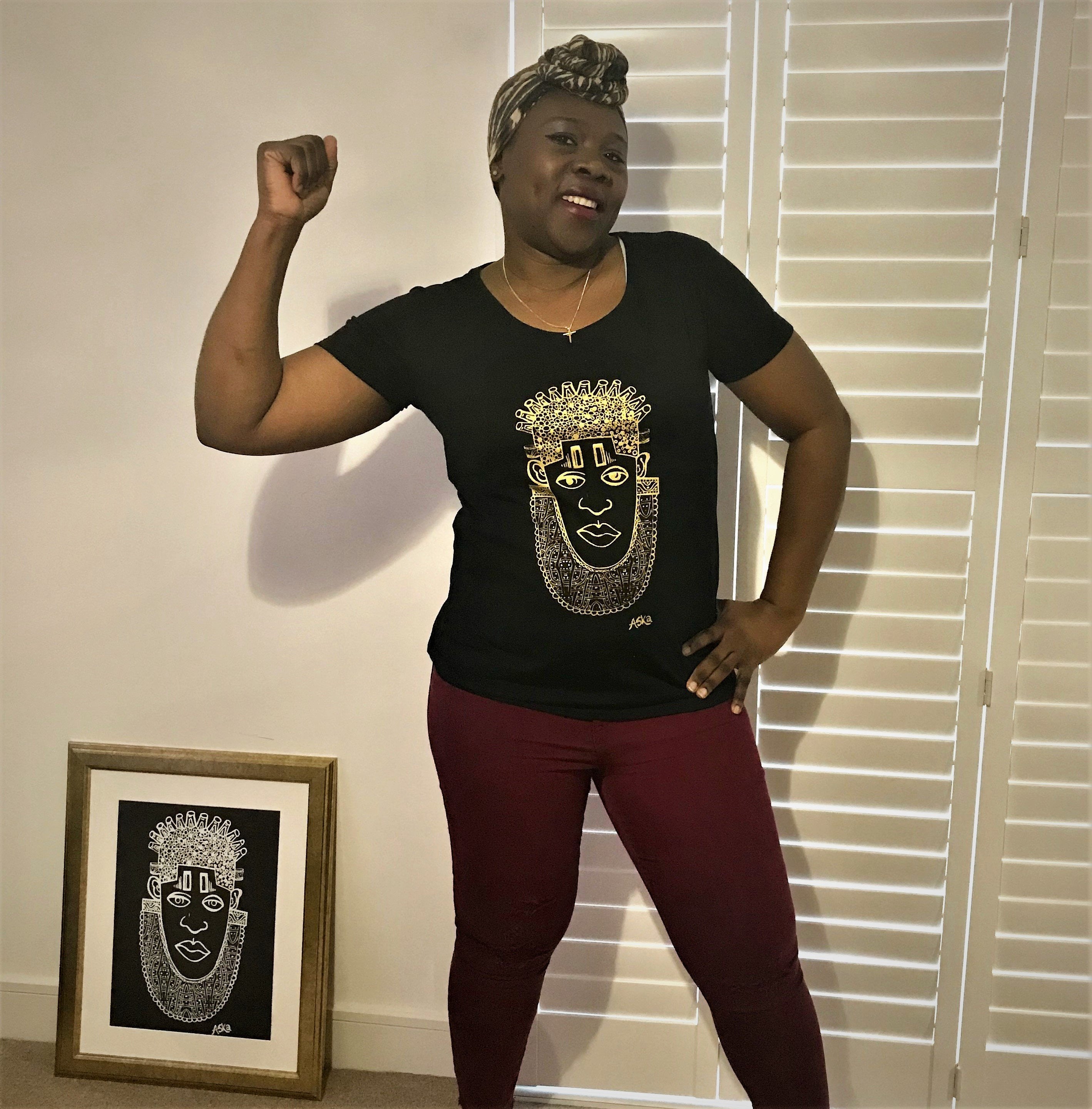 IDIA in Gold Art Earth Positive Tee featuring a gold print of Queen Idia on a black scooped neck shirt made from 100% organic cotton.