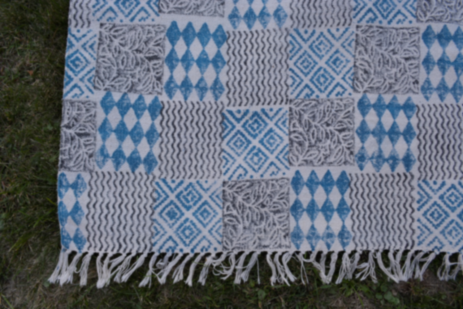 Indigo dyed handwoven cotton rug featuring a floral design, showcasing intricate block printing and a beautiful blue background.