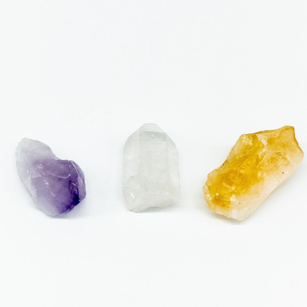 Insight + Energy Crystal Set featuring Amethyst, Citrine, and Crystal Quartz in a small white pouch.