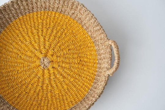 Iris Round Tray I Olive, a handwoven seagrass tray with vibrant yellow circular design, perfect for serving or organizing.