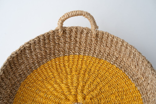 Iris Round Tray I Olive, a handwoven seagrass tray with vibrant yellow circular design, perfect for serving or organizing.