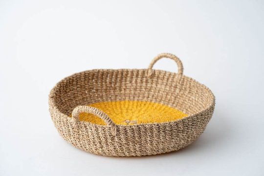 Iris Round Tray I Olive, a handwoven seagrass tray with vibrant yellow circular design, perfect for serving or organizing.