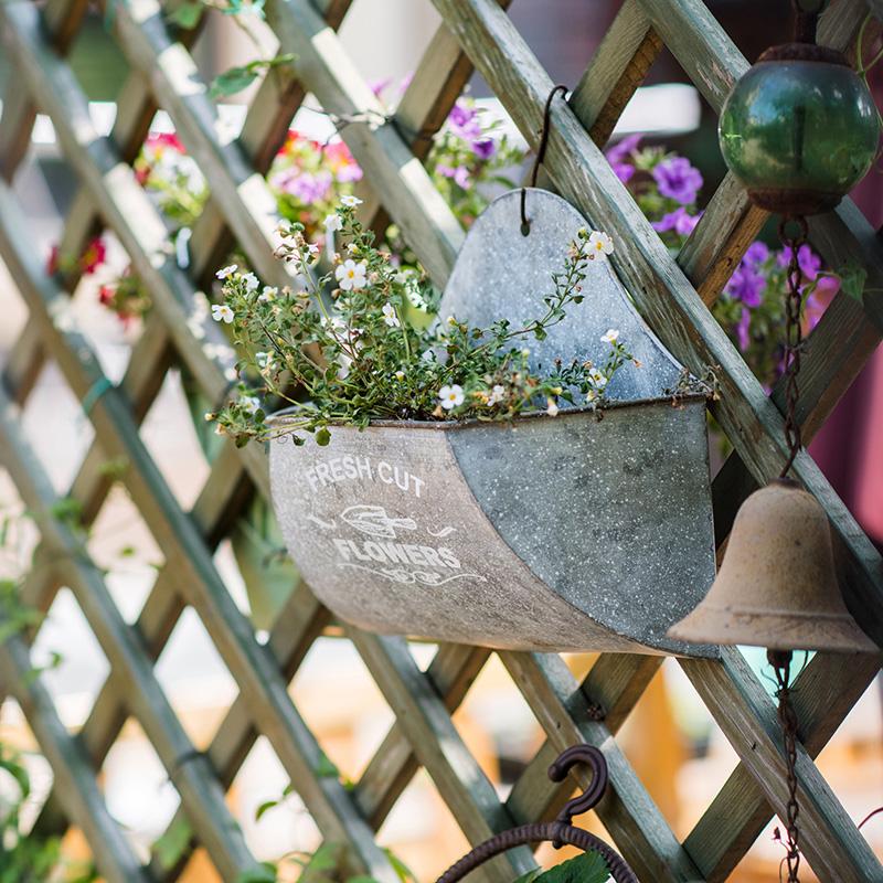 Iron Flower Wall Planter in gray with white letters, showcasing a stylish design for indoor and outdoor use.