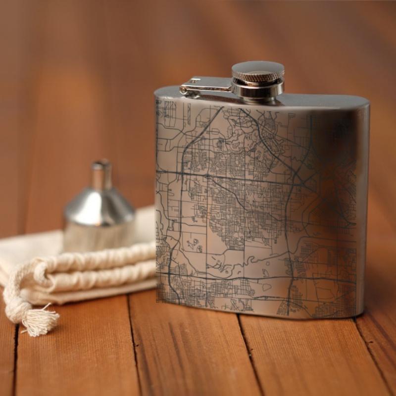 Custom engraved 6oz hip flask featuring a map of Irving, Texas with coordinates, accompanied by a canvas bag and funnel.