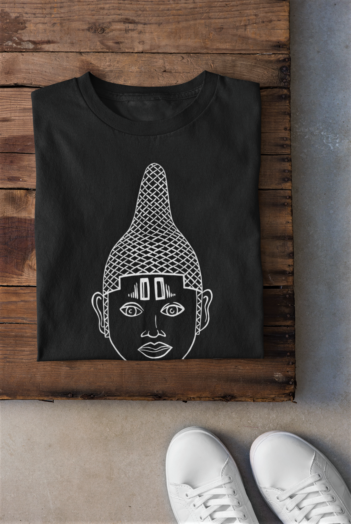 IYOBA Art Earth Positive Tee featuring Queen IDIA's face in black, white, and rose-gold prints on a white and black background, made from organic cotton.