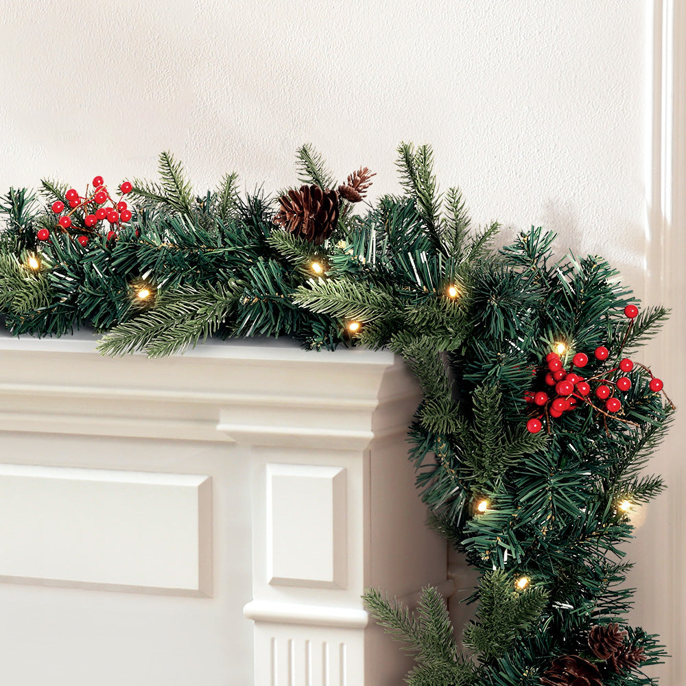 Jingle Jollys 2.4M Christmas Garland with warm LED lights, artificial berries, and pinecones, perfect for festive decoration.