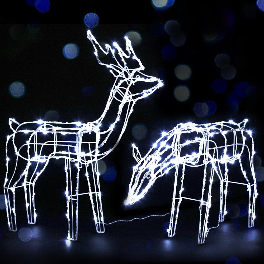 Two LED reindeer lights in feeding and standing positions, illuminated with bright LEDs, set against a snowy background.