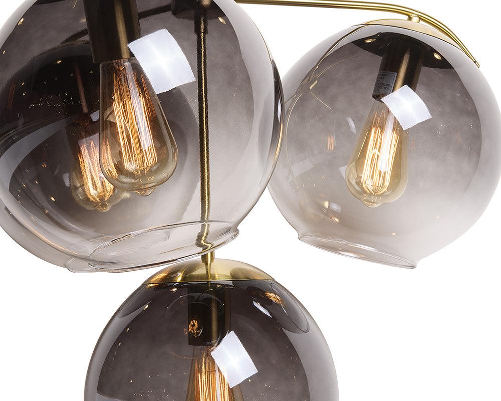 Kamara Chandelier in brass with glass accents, showcasing elegant design and adjustable hanging length.