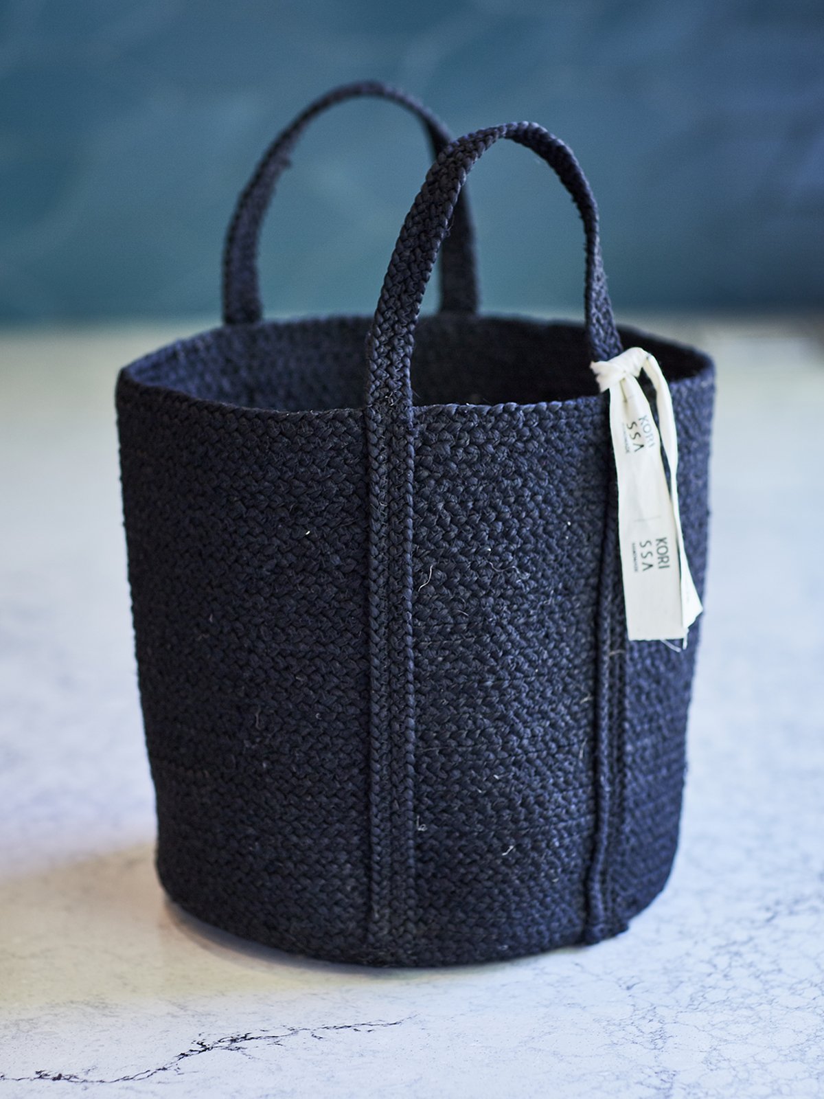 Kata Basket with handle in black, made from braided jute, showcasing its unique texture and design.