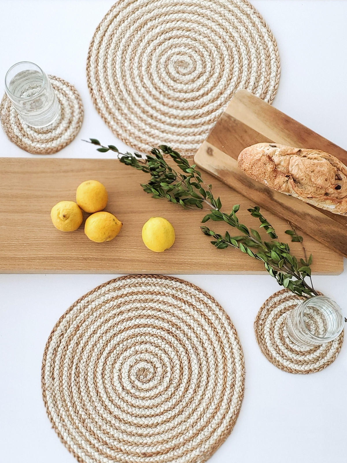 Set of 4 natural jute round placemats with braided texture, perfect for dining tables.