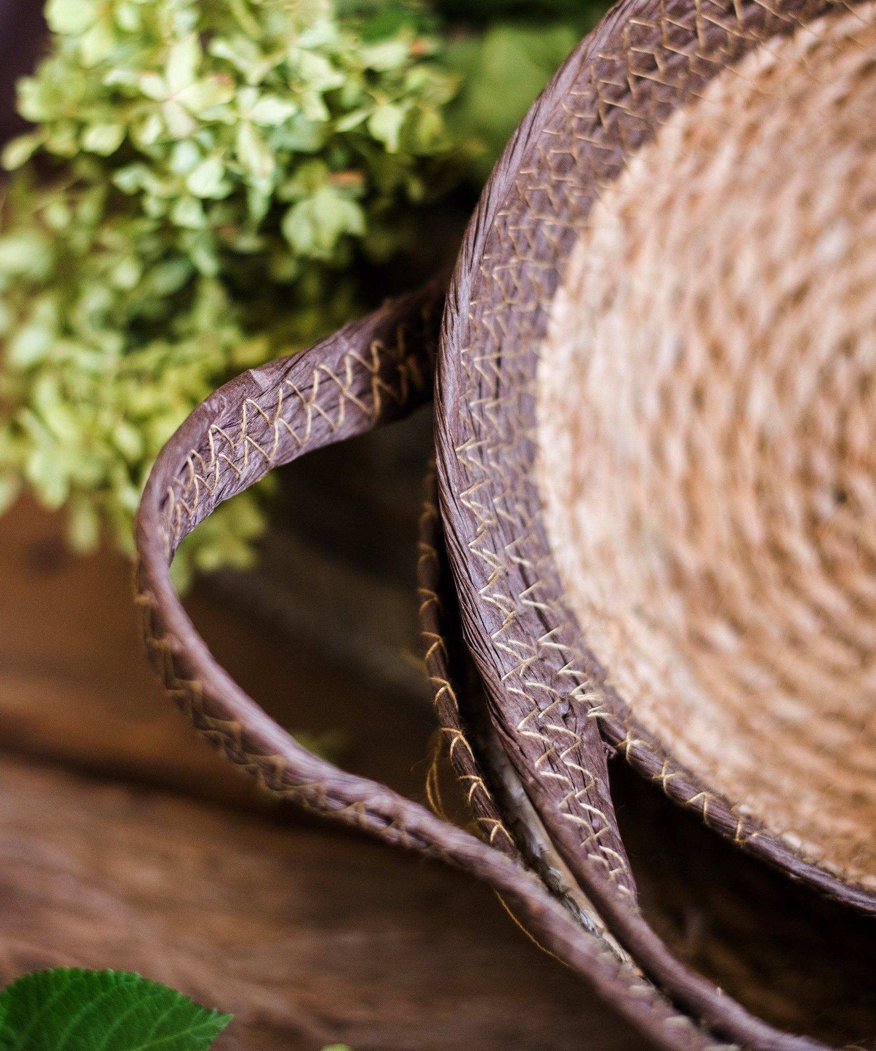 Khaki brown straw basket with handles, showcasing its natural straw texture and elegant design.