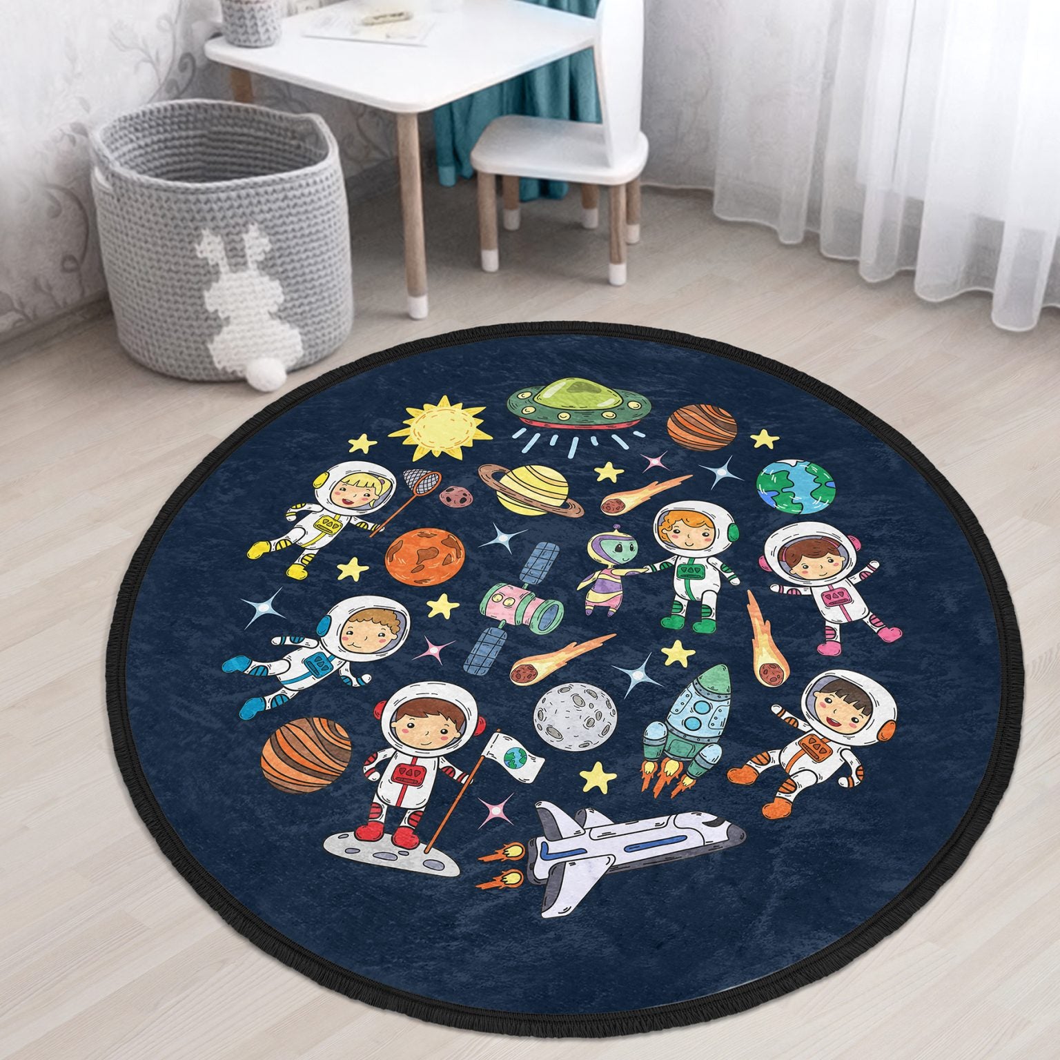 Round kids room area rug with a cute space design, featuring vibrant colors and fringed edges, perfect for nurseries and playrooms.