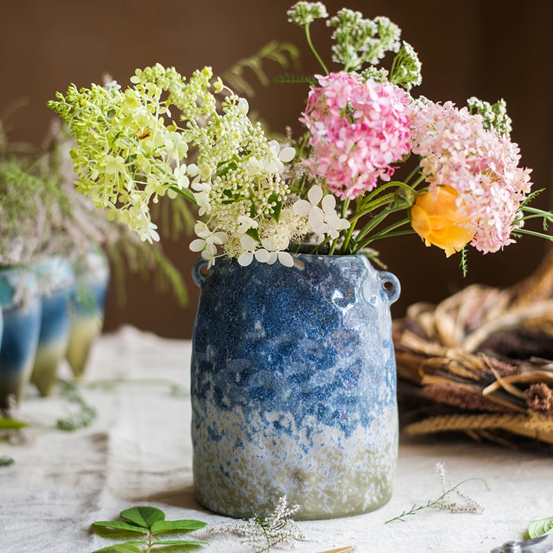 A beautifully handcrafted Kiln Glazed Blue Vase featuring a mix of blue, white, and tan colors, showcasing unique shapes and a glossy finish.