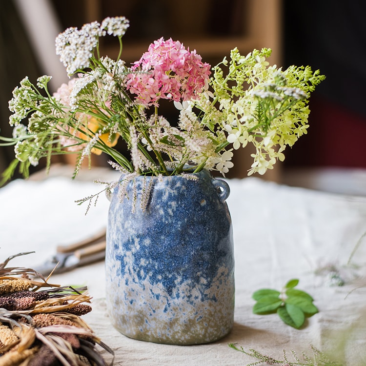 A beautifully handcrafted Kiln Glazed Blue Vase featuring a mix of blue, white, and tan colors, showcasing unique shapes and a glossy finish.