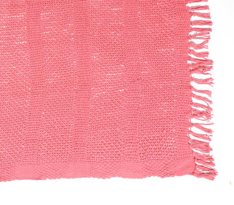 A hand-knitted coral red throw with tassels, showcasing intricate craftsmanship and vibrant color.