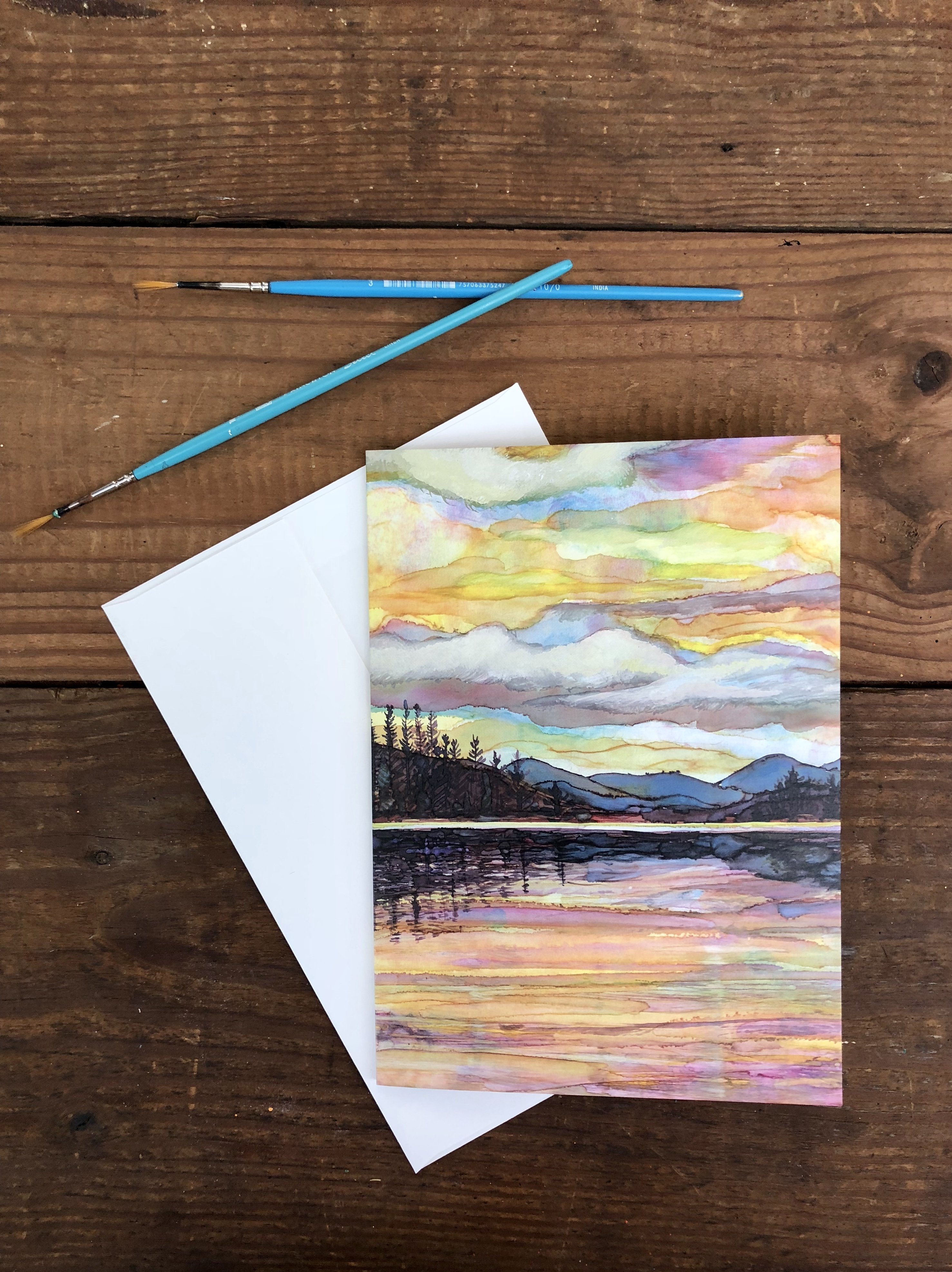 Lake Sunset Greeting Card featuring dual landscape paintings on the cover and inside, printed on heavyweight matte paper.