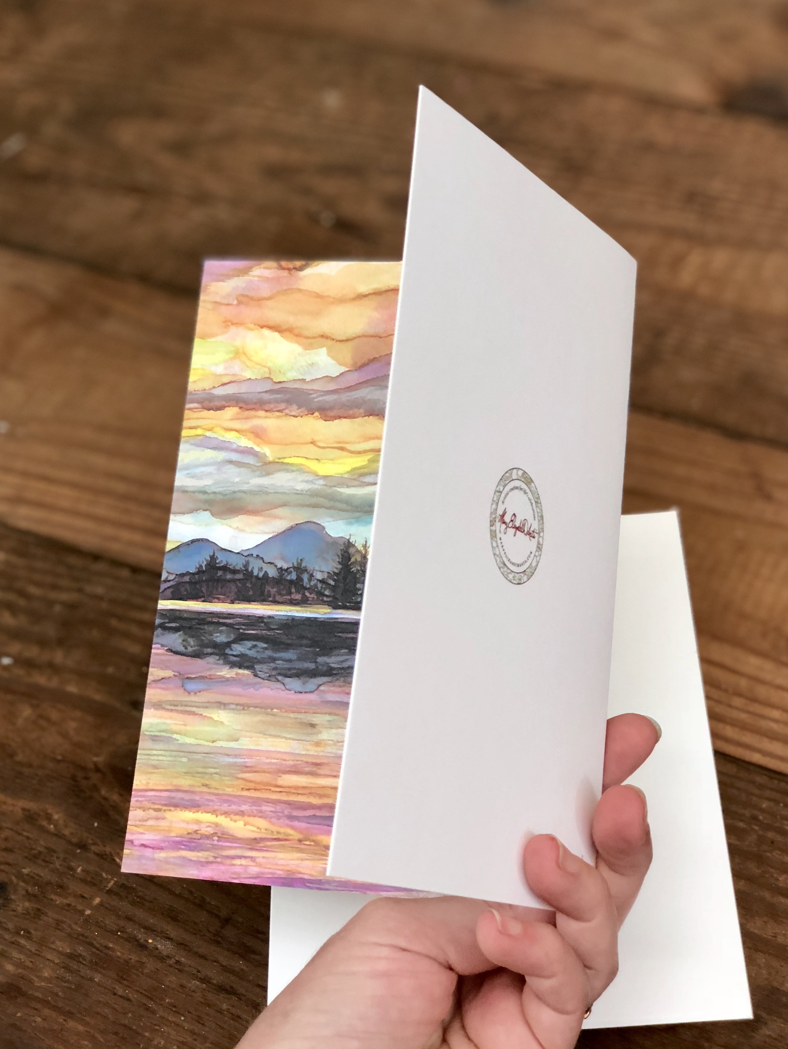 Lake Sunset Greeting Card featuring dual landscape paintings on the cover and inside, printed on heavyweight matte paper.