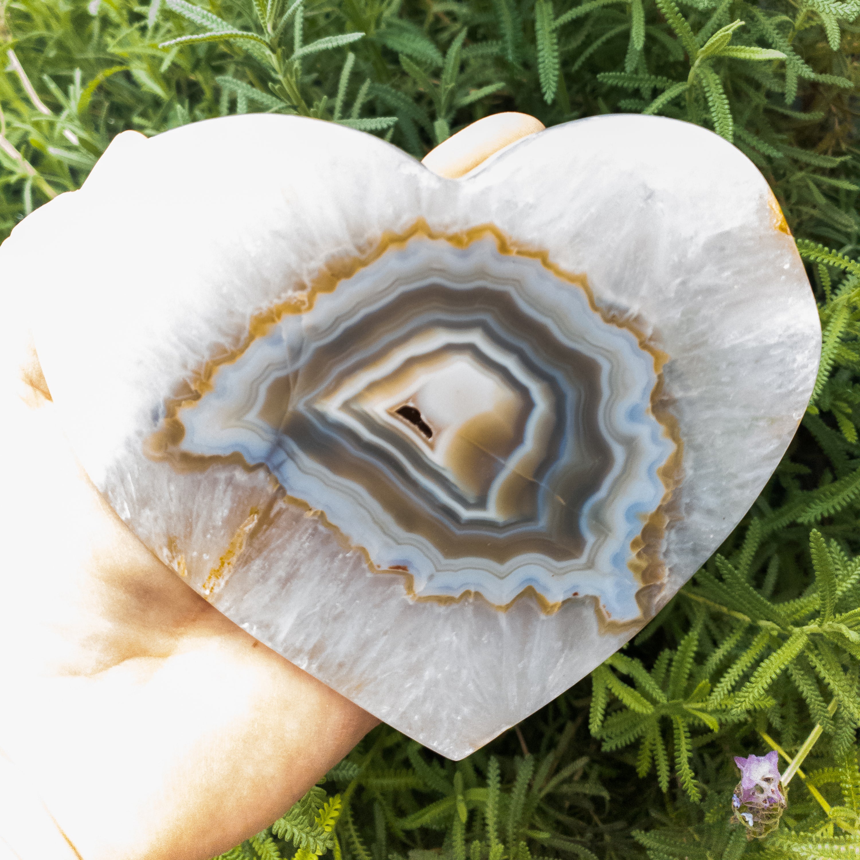 A large heart-shaped agate stone, showcasing vibrant colors and unique patterns, handcrafted by Brazilian artisans.