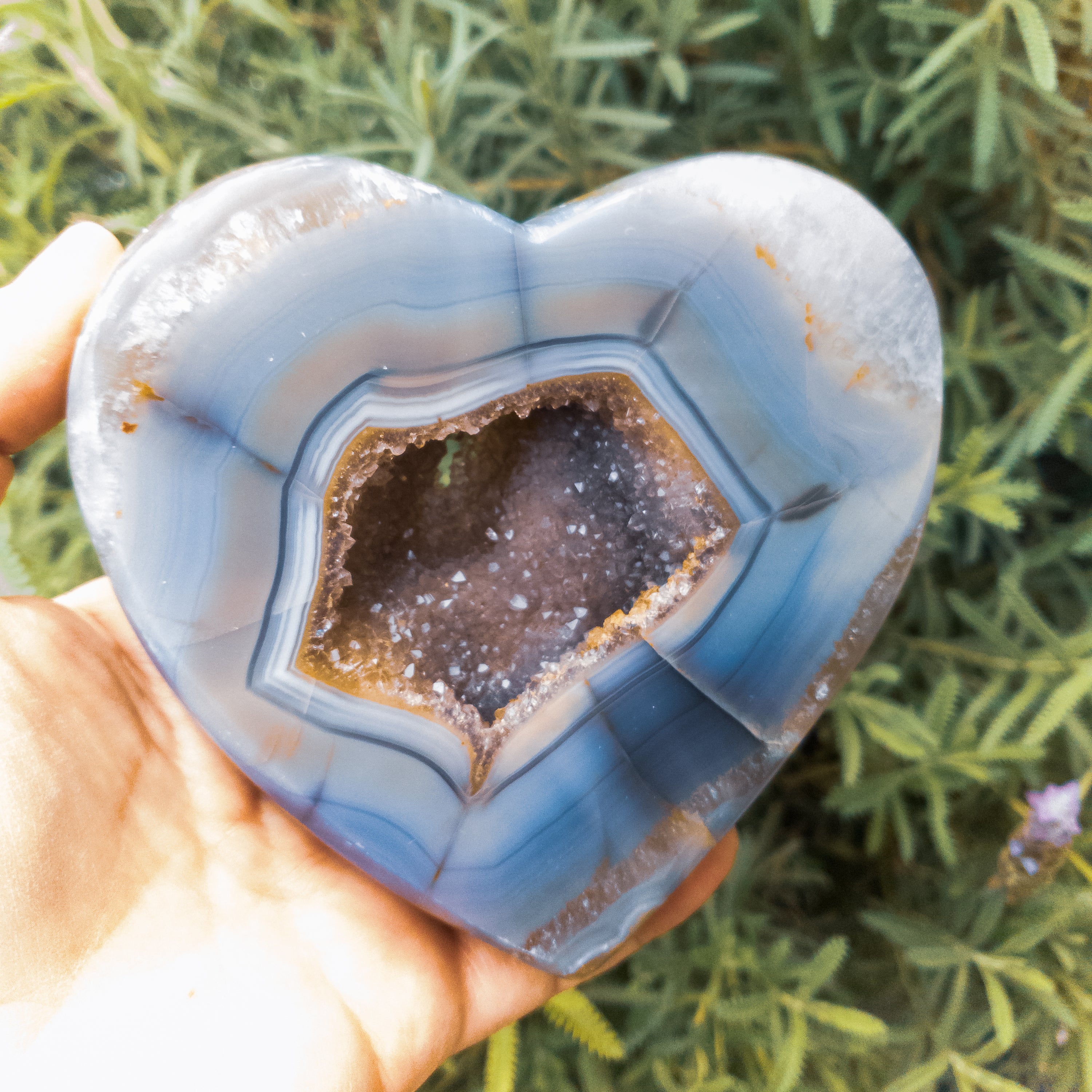 A large heart-shaped agate stone, showcasing vibrant colors and unique patterns, handcrafted by Brazilian artisans.