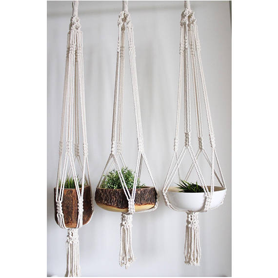 Large macrame plant hanger made of 100% cotton rope, featuring intricate knots and tassels, designed to hold pots up to 12 inches in diameter.