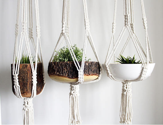 Large macrame plant hanger made of 100% cotton rope, featuring intricate knots and tassels, designed to hold pots up to 12 inches in diameter.