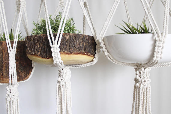 Large macrame plant hanger made of 100% cotton rope, featuring intricate knots and tassels, designed to hold pots up to 12 inches in diameter.