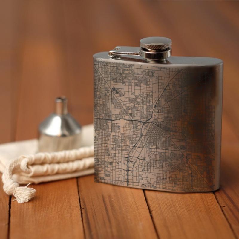 Custom engraved 6oz hip flask featuring a detailed map of Las Vegas, Nevada, with coordinates, accompanied by a canvas bag and funnel.