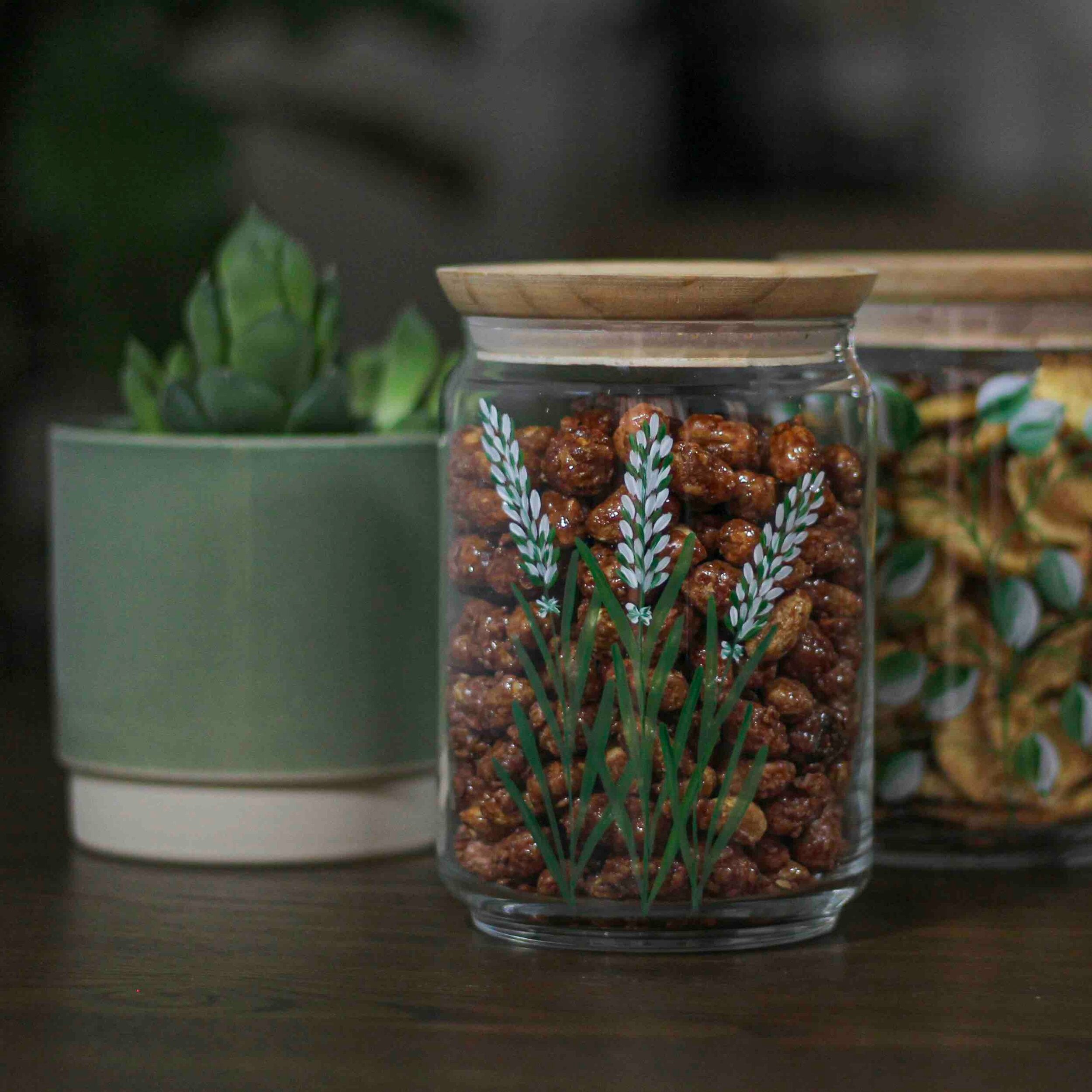 A beautifully hand-painted 1L glass jar with an airtight seal, ideal for storing dry foods like flour and rice.