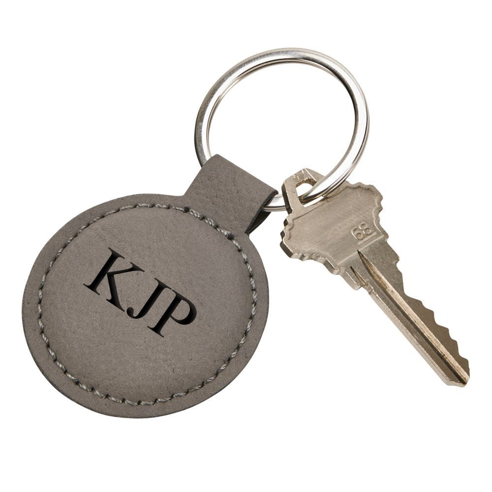 Grey leatherette round keychain with stitching, 1.875 inches in diameter, featuring a smooth surface for engraving.