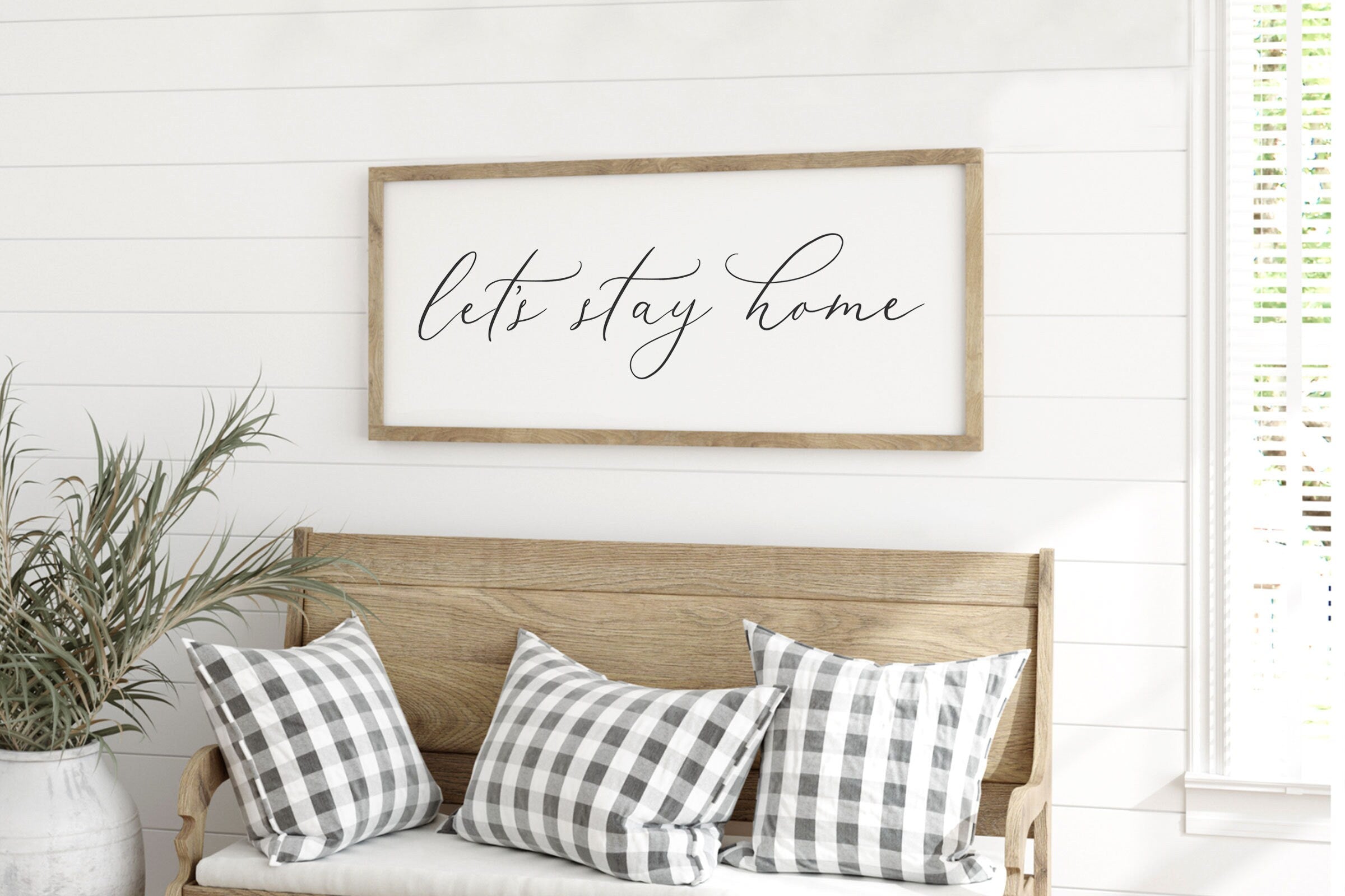 Rustic 'Let's Stay Home' farmhouse wood sign with unique wood grain and painted lettering, framed in customizable stain color.