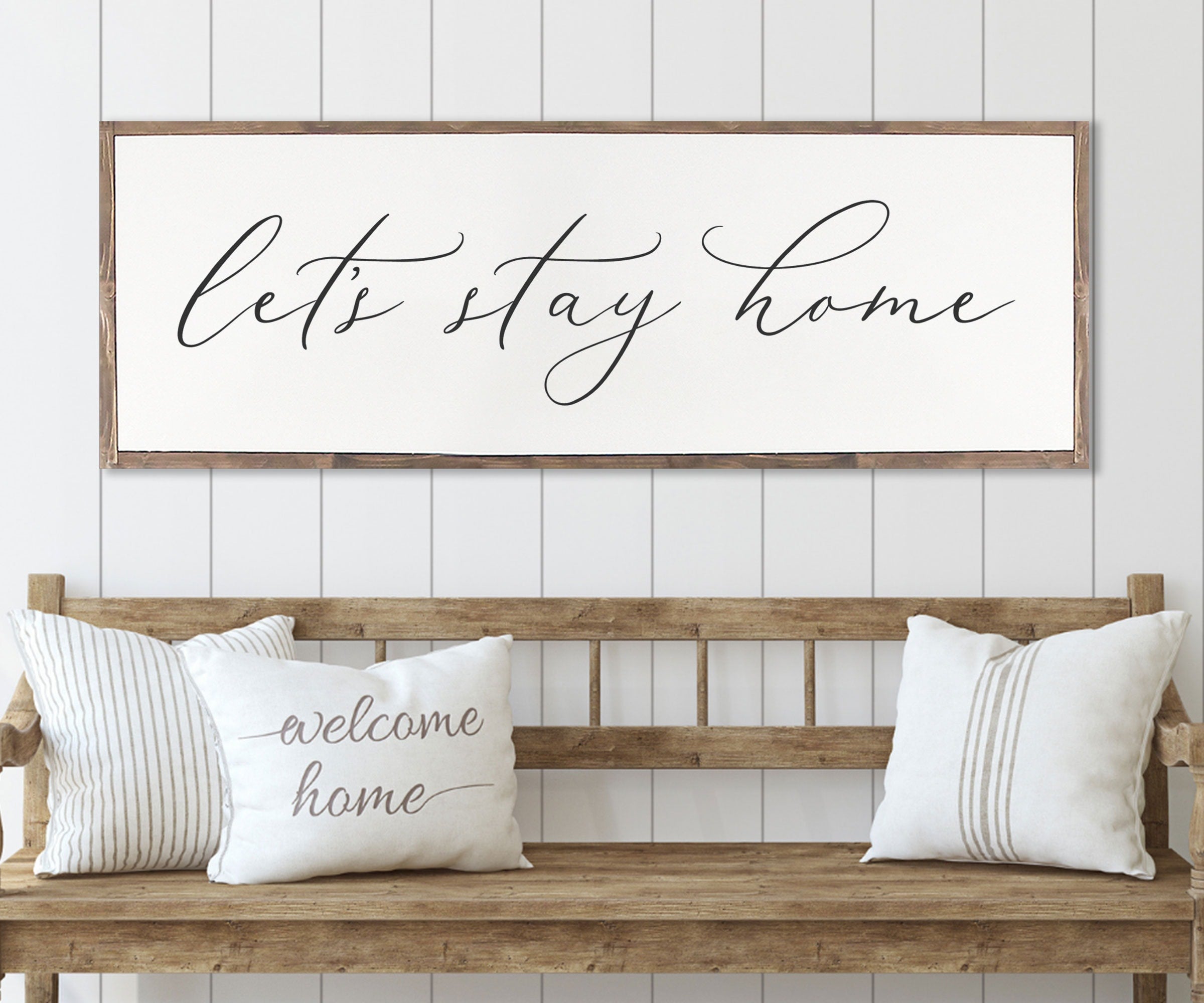 Rustic 'Let's Stay Home' farmhouse wood sign with unique wood grain and painted lettering, framed in customizable stain color.