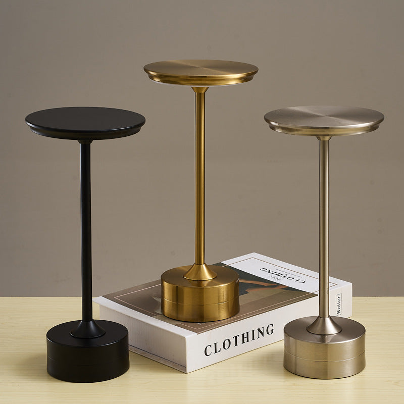 Lámpara de mesa recargable en colores oro, plata y negro, con diseño moderno y minimalista, ideal para decoración y funcionalidad.