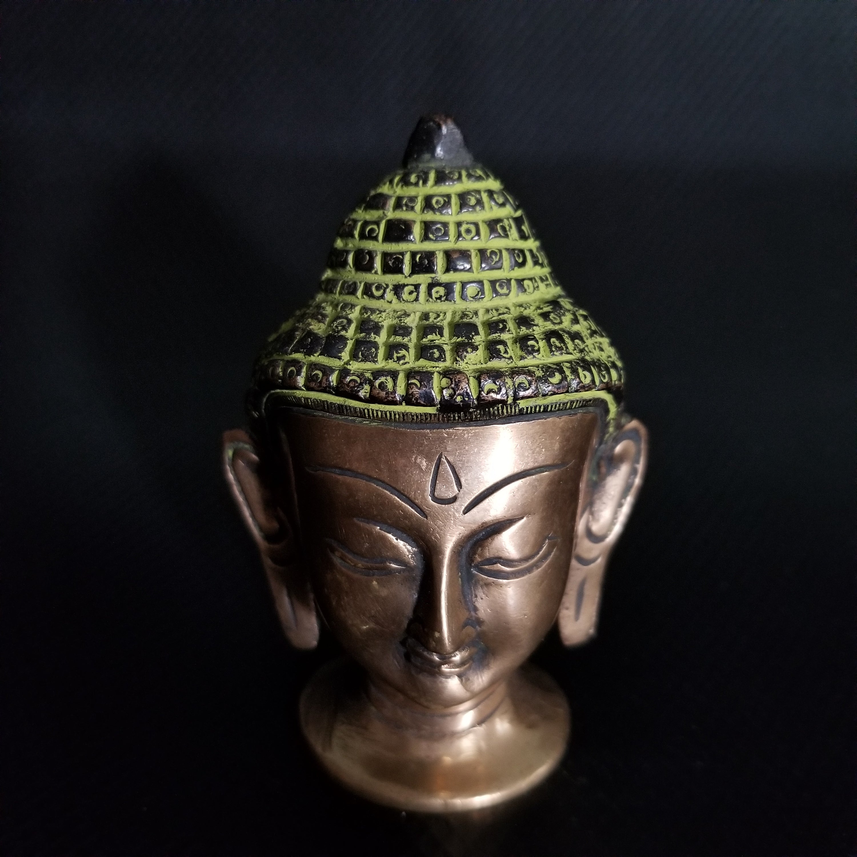 A beautifully handcrafted Lord Buddha Head Brass statue showcasing intricate details, antique green paint, and a vintage patina finish.