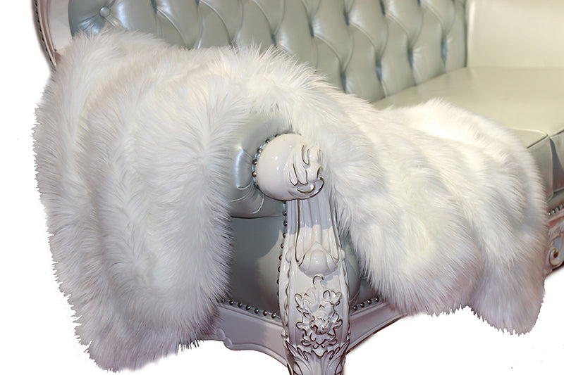 Luxury Decorative White Faux Fur Throw blanket draped elegantly over a sofa, showcasing its plush texture and soft, velvety backing.