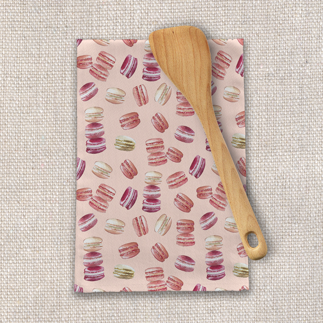 A colorful macaron-themed tea towel made of cotton twill, featuring a charming design perfect for kitchen decor.