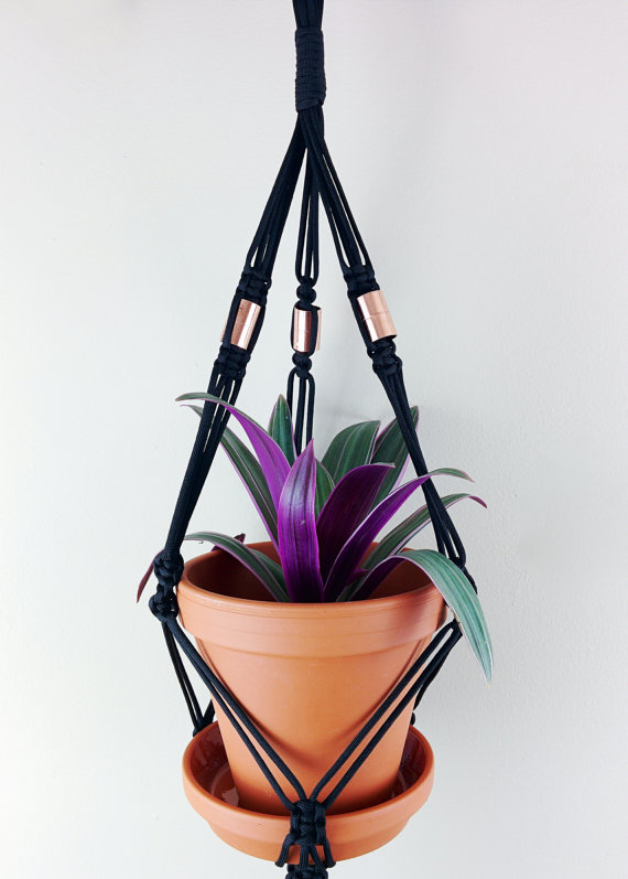 A stylish macrame plant hanger made from durable nylon cord, featuring intricate knots and designed to hold pots from 4 to 6.5 inches in diameter, perfect for indoor and outdoor use.