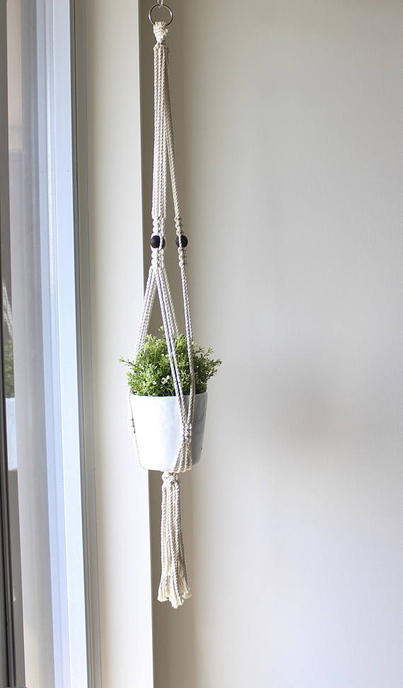 A beautifully crafted macrame plant hanger made from 100% cotton rope with textured wooden beads, showcasing a stylish design suitable for indoor and outdoor use.