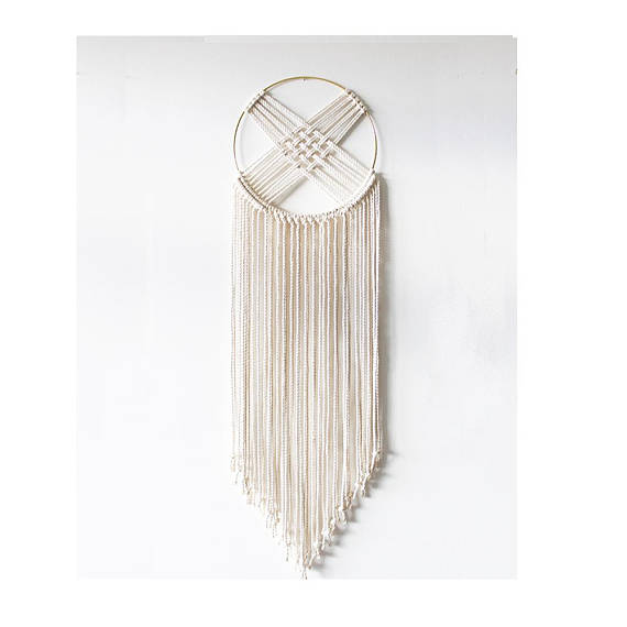 Handcrafted macrame wall hanging featuring a gold metal hoop and intricate cotton rope design, perfect for home or office decor.