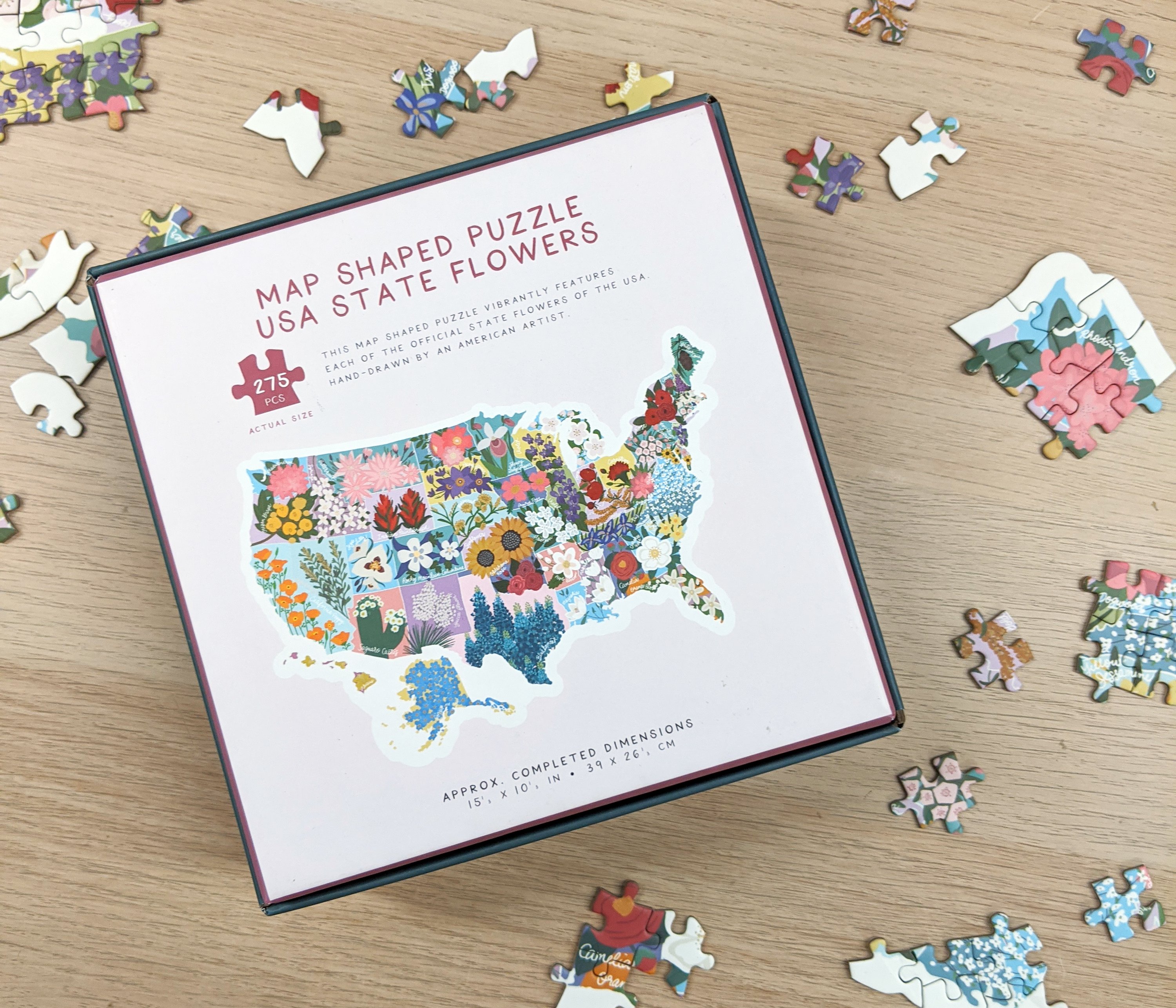 Map shaped jigsaw puzzle featuring US state flowers, colorful and detailed design with unique pieces.