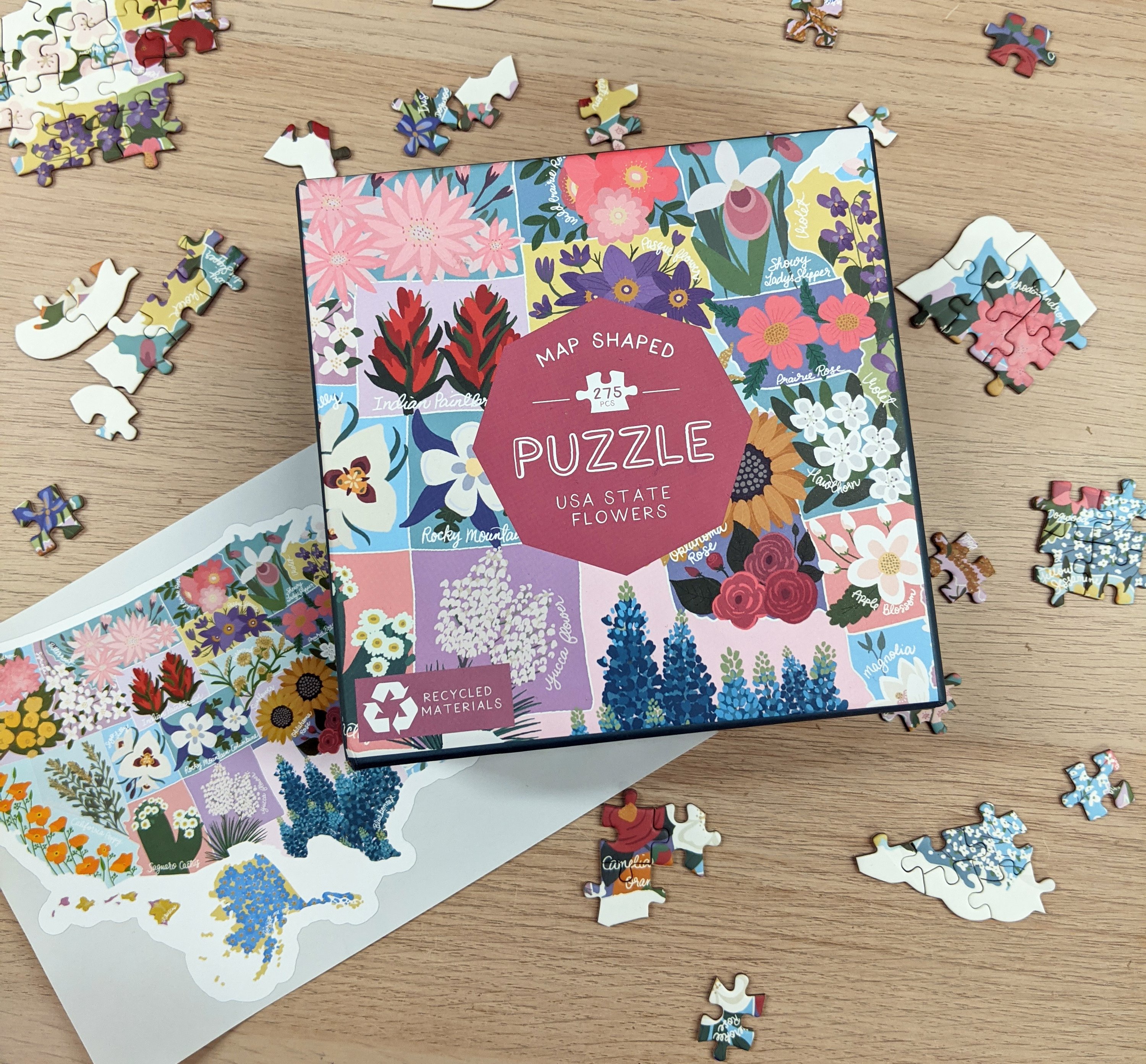 Map shaped jigsaw puzzle featuring US state flowers, colorful and detailed design with unique pieces.