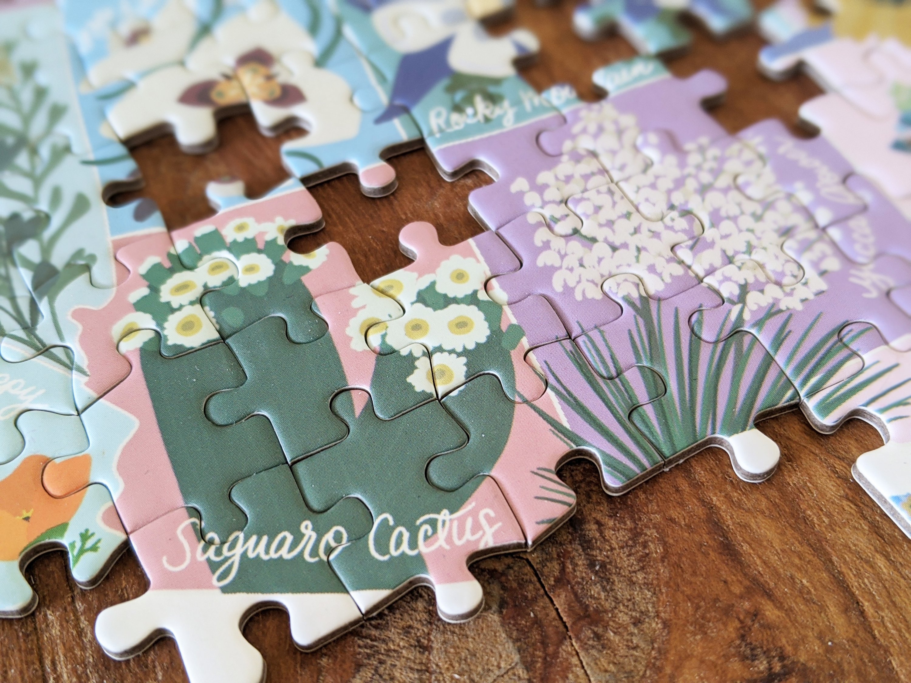 Map shaped jigsaw puzzle featuring US state flowers, colorful and detailed design with unique pieces.