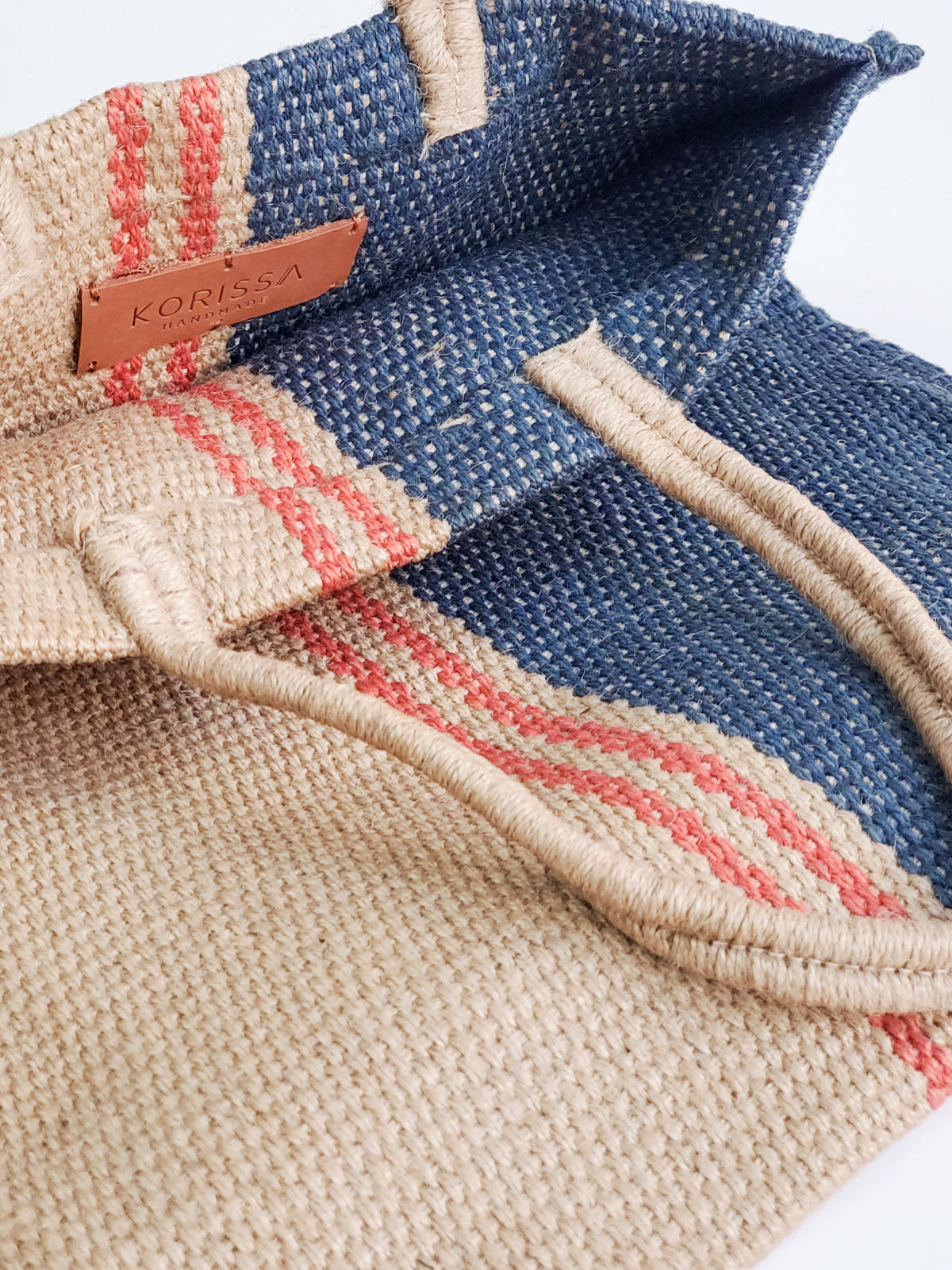 Maya Jute Tote Bag in natural, navy, and red colors, showcasing its handwoven texture and spacious design.