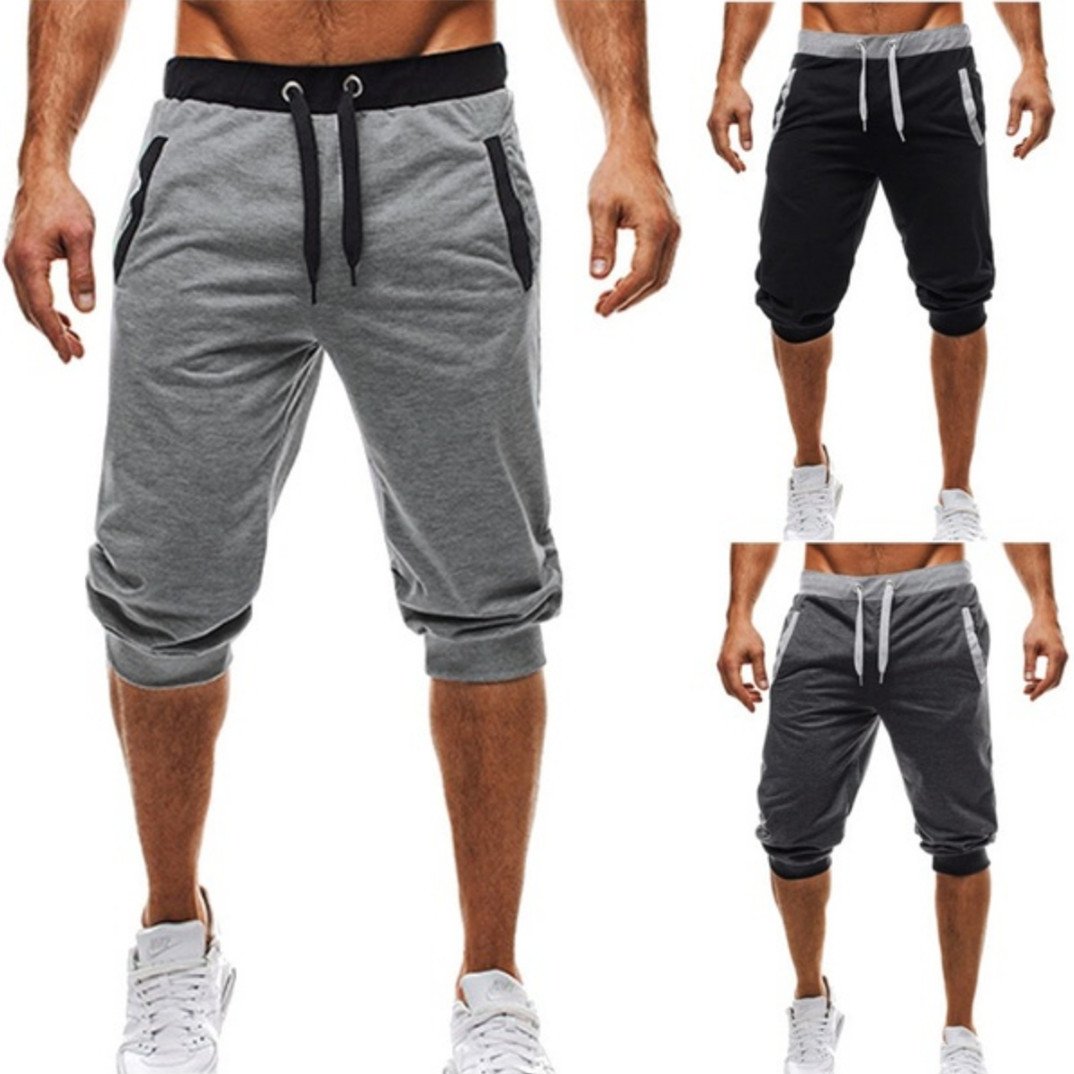 Men's cropped pants in solid colors, showcasing elastic waist and drawstring, perfect for summer wear.