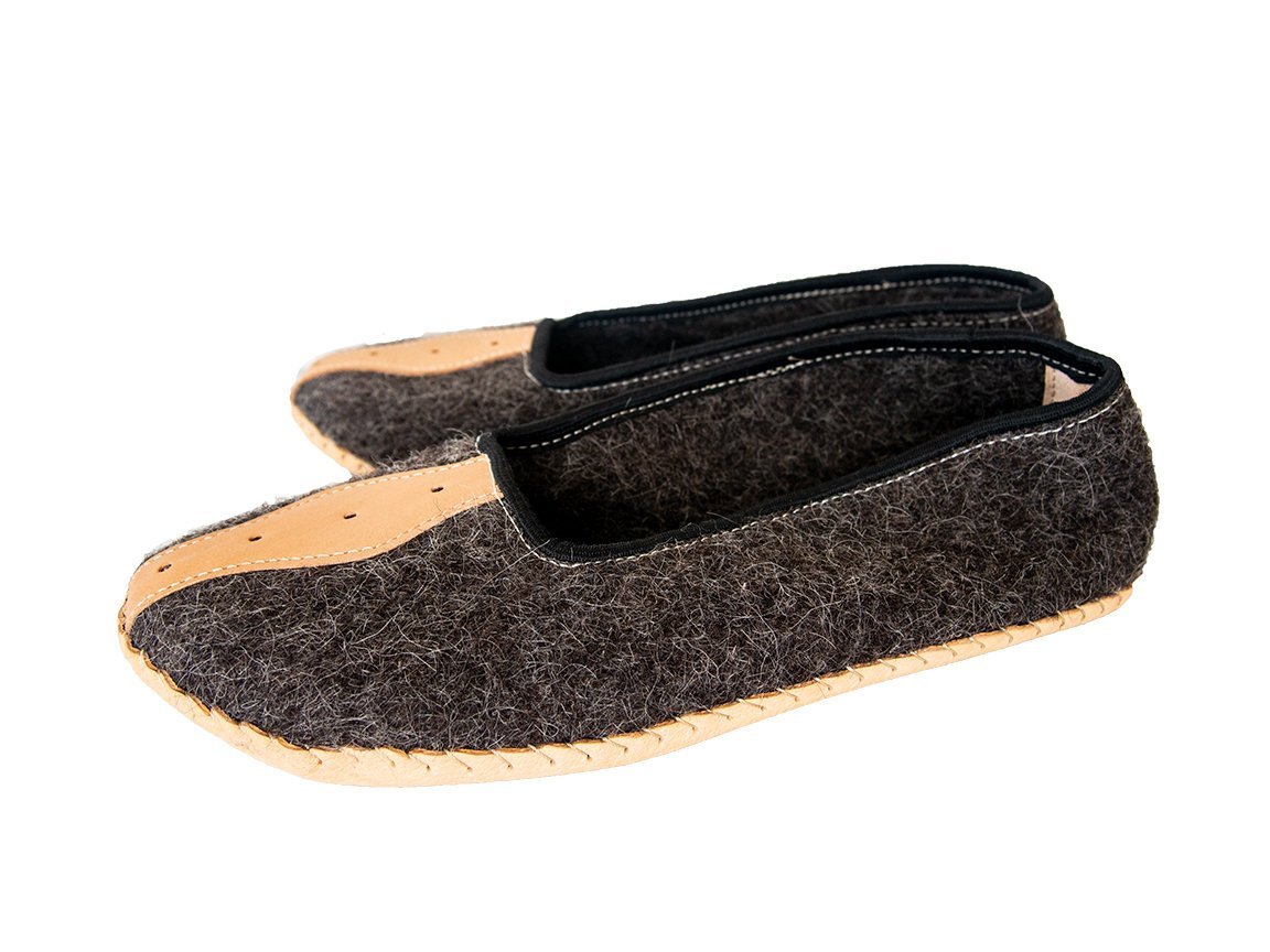 A pair of elegant mens slippers made from felt and genuine leather, showcasing their handcrafted quality and stylish design.