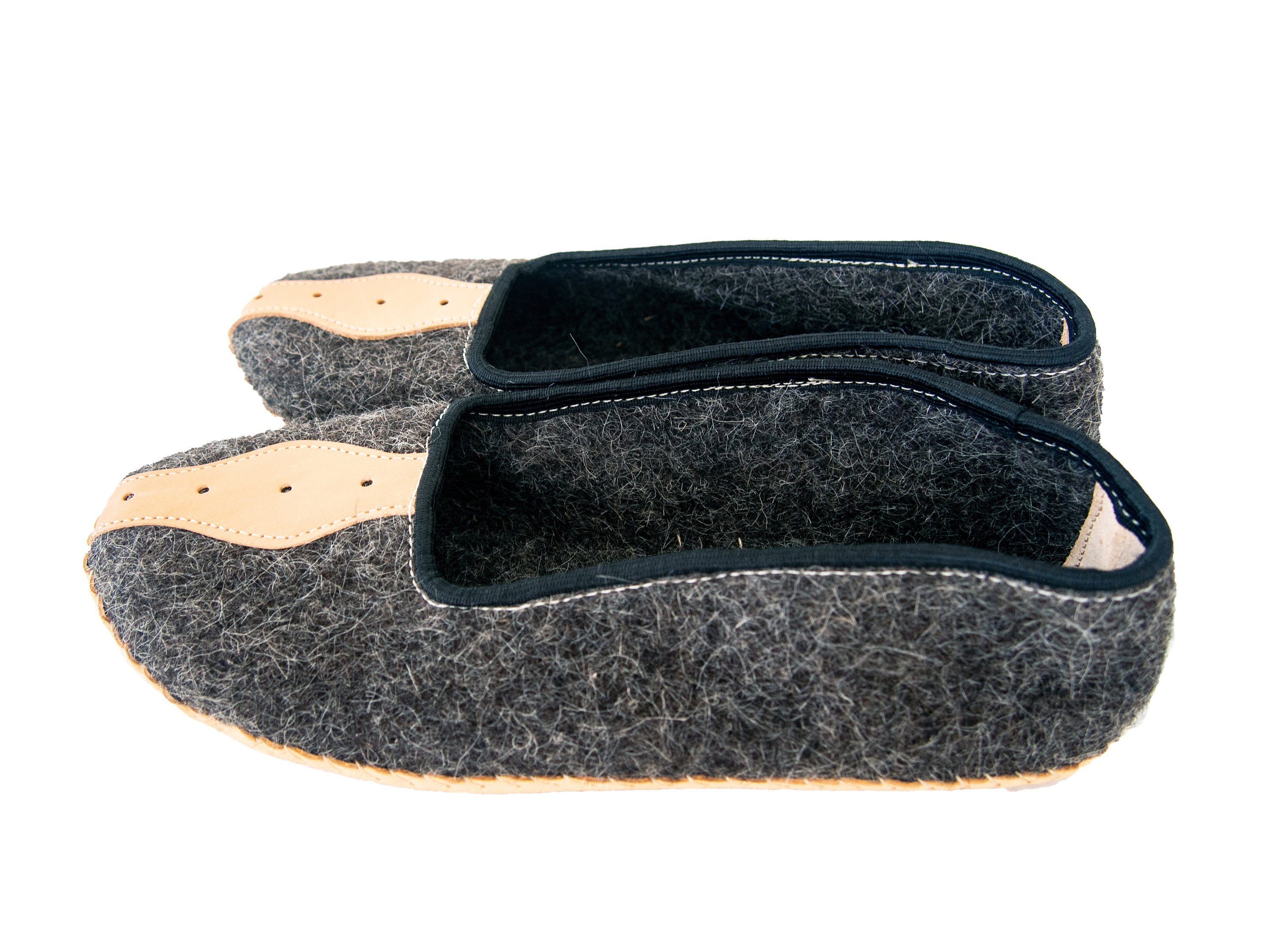 A pair of elegant mens slippers made from felt and genuine leather, showcasing their handcrafted quality and stylish design.