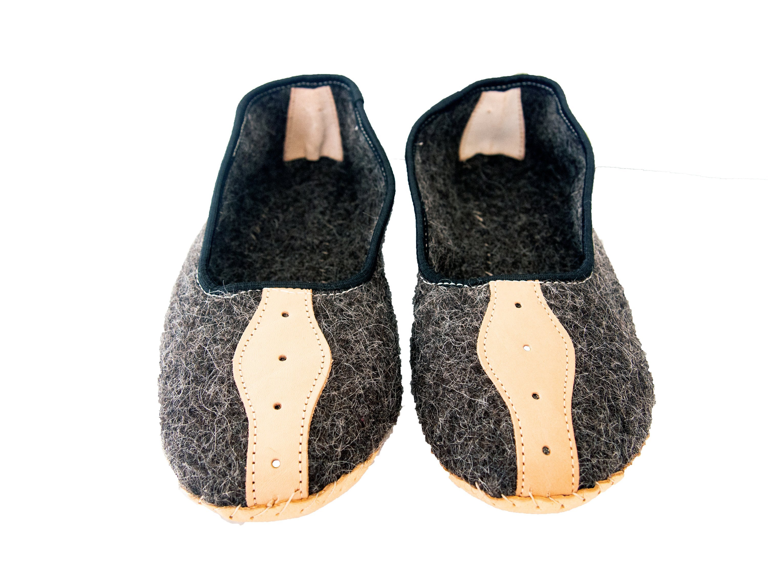 A pair of elegant mens slippers made from felt and genuine leather, showcasing their handcrafted quality and stylish design.