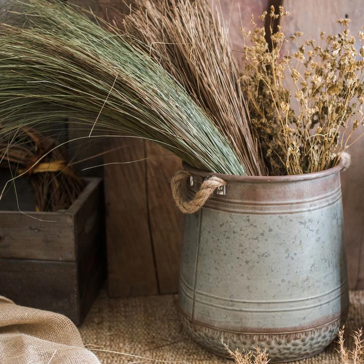 Metal flower pail with rope handles in gray and rusty colors, perfect for decorative floral arrangements.