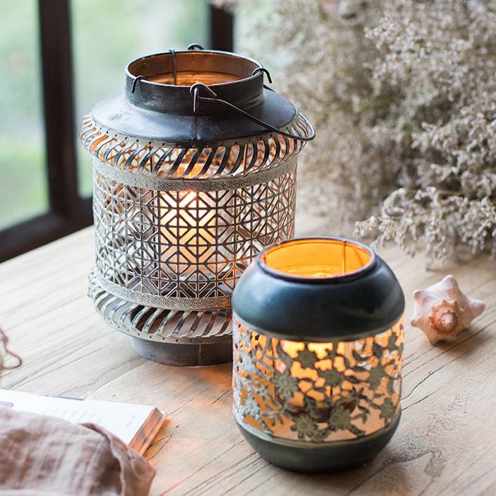 A rustic metal lantern candle holder made of rusted iron, showcasing unique colors and shapes, perfect for home decor.