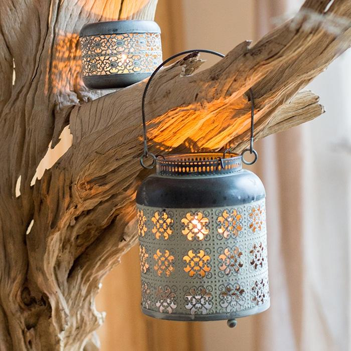 A rustic metal lantern candle holder made of rusted iron, showcasing unique colors and shapes, perfect for home decor.