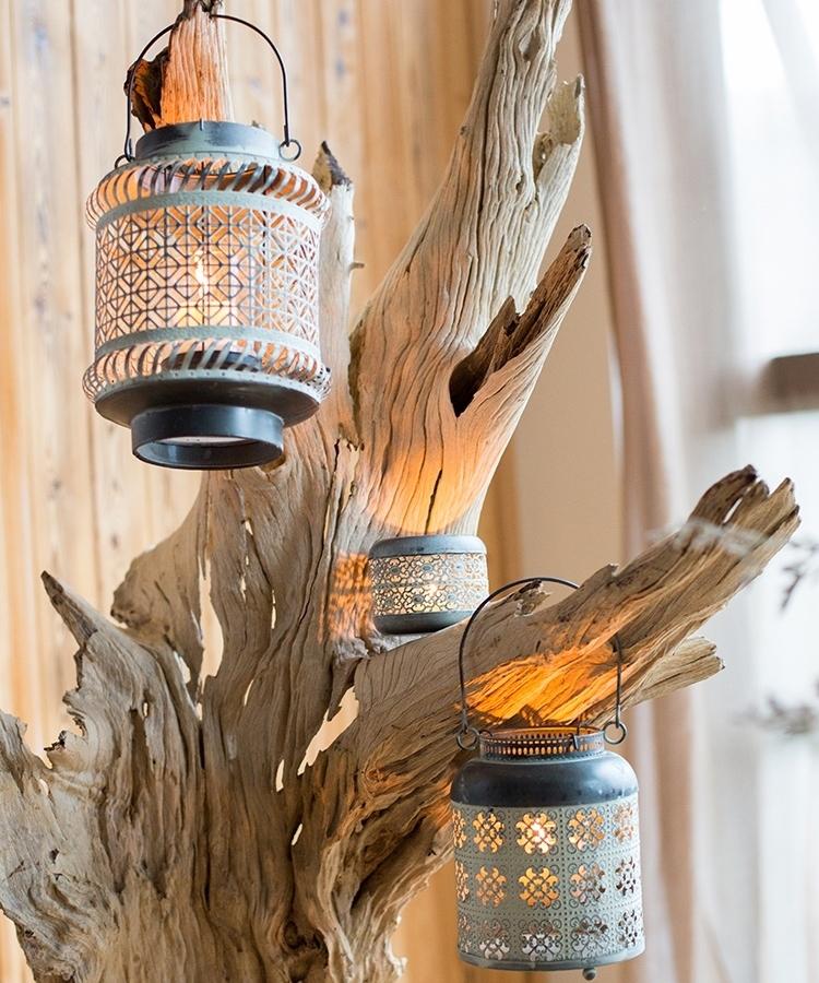 A rustic metal lantern candle holder made of rusted iron, showcasing unique colors and shapes, perfect for home decor.